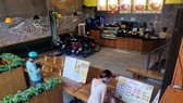 Một quán ăn kê bàn để giữ khoảng cách 2 mét giữa khách và nhân viên nhằm phục vụ cho những món mang về