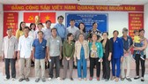 Người dân có hoàn cảnh khó khăn ở huyện Bình Chánh, TPHCM được tặng thẻ BHYT. Ảnh: VIỆT NGA