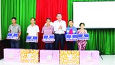 Ông Lưu Hoàng Tân - Chủ tịch, Giám đốc Công ty TNHH MTV Xổ số kiến thiết Đồng Tháp trao bảng tượng trưng và quà cho 5 hộ nghèo