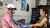 Cán bộ tại Quận 10 (TPHCM) phát tờ rơi tuyên truyền đến từng hộ dân trong địa bàn quận. Ảnh: KIM HUYỀN