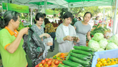 Consumers buy vegetables at a clean farm produce fair in HCMC (Photo: SGGP)