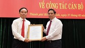 Head of the Commission for Organizing and Personnel of the Communist Party of Vietnam Pham Minh Chinh (R) gives the Politburo’s decision to appoint Mr. Tran Luu Quang to the standing deputy secretary of HCMC Party Committee on February 27 (Photo: SGGP)