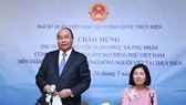 Prime Minister Nguyen Xuan Phuc (standing) speaks at the meeting with the Vietnamese Embassy staff and expatriates in Sweden. (Photo: VNA)