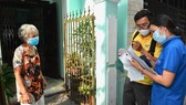 Bưu tá và chuyên viên UBND phường Tân Định (quận 1, TPHCM) tới nhà chi trả chế độ ưu đãi người có công với cách mạng. Ảnh: VIỆT DŨNG