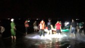 Lực lượng chức năng và người dân đưa thuyền gặp nạn vào bờ