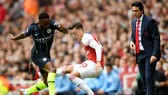 Ở Man.City, một cầu thủ tấn công như Raheem Sterling (trái) cũng lùi về để tranh bóng với Mesut Oezil. Ảnh: Getty Images