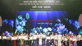Thủ tướng Nguyễn Xuân Phúc trao bằng khen của Thủ tướng Chính phủ cho những cá nhân và điển hình tiên tiến trong học tập và làm theo tấm gương đạo đức Hồ Chí Minh trong chương trình giao lưu điển hình toàn quốc 2019. Ảnh: TRẦN BÌNH