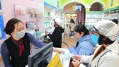 Một số cửa hàng tặng khẩu trang cho khách hàng. Ảnh: TTXVN