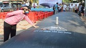 Người dân tham quan túi chứa nước ngọt do các doanh nghiệp giới thiệu để ứng phó với xâm nhập mặn. Ảnh: HỮU HIỆP