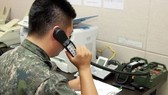 Bộ Thống nhất Hàn Quốc cho biết, đến trưa 9-6, việc liên lạc qua điện thoại với Triều Tiên đã không thể thực hiện được. Trong ảnh: Một sĩ quan Quân đội Hàn Quốc đang sử dụng đường dây nóng quân sự để liên lạc với Triều Tiên. Ảnh: YONHAP
