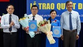 Phó Bí thư Thường trực Thành ủy TPHCM Trần Lưu Quang (bìa trái) và Trưởng ban Công tác phía Nam Cơ quan Ủy ban Trung ương MTTQ Việt Nam Võ Văn Thiện (bìa phải) trao quyết định nhân sự mới