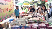 Khách hàng chọn mua các loại bánh mứt và đặc sản của tỉnh Đồng Tháp tại phiên chợ “Tết xanh - quà Việt” tổ chức tại TPHCM từ ngày 17 đến 22-1