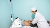 Bác sĩ xác định huyệt để thực hiện phương pháp laser châm