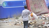 Vô tư vứt rác vào một bãi rác tự phát Ảnh: THÀNH TRÍ
