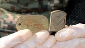 Tấm thẻ quân nhân và phù hiệu được tìm thấy cùng bộ hài cốt được cho là của một binh sĩ Hàn Quốc tử trận trong Chiến tranh Triều Tiên 1950-1953 tại Khu phi quân sự (DMZ) ở biên giới hai miền Triều Tiên, ngày 24-10-2018. Ảnh: Yonhap/TTXVN