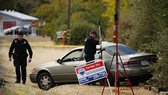 Law enforcement officers examine a vehicle that was involved in a shooting Tuesday, in Rancho Tehama, California. Four people were killed and nearly a dozen were wounded, including several children, when a gunman went on a rampage at multiple locations, i