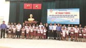 Ông Lê Văn Công, Kiểm Soát viên Công ty TNHH Một thành viên Xổ số kiến thiết TP Hồ Chí Minh cùng với lãnh đạo UBMTTQ TP, UBMTTQ huyện Nhà Bè và đơn vị Tài trợ chụp hình lưu niệm cùng với các em học sinh, sinh viên nhận học bổng