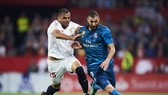 Karim Benzema (phải, Real Madrid) tranh bóng với Gabriel Mercado (Sevilla)