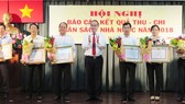 Bí thư Thành ủy TPHCM Nguyễn Thiện Nhân trao tặng bằng khen của UBND TPHCM đối với các địa phương hoàn thành xuất sắc công tác thu nộp ngân sách Nhà nước trên địa bàn thành phố năm 2018. Ảnh: KIỀU PHONG