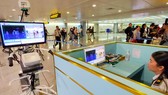 Hành khách khi đến sân bay Tân Sơn Nhất - TPHCM đều được kiểm tra thân nhiệt để phòng chống bệnh Covid-19. Ảnh: HOÀNG HÙNG