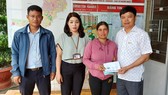 Ông Nguyễn Hữu Quế (bên phải), Chủ tịch UBND TP Pleiku phối hợp với đại diện Báo SGGP (bên trái) cùng UBND phường Trà Bá (thứ 2 từ trái qua) trao tiền hỗ trợ của bạn đọc Báo SGGP cho gia đình em Liên