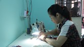 Bà Võ Thị Phương Lan đang miệt mài may những chiếc khẩu trang tại nhà