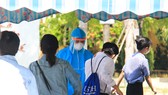 Các thí sinh được tiến hành đo thân nhiệt, sát khuẩn tay và thay khẩu trang trước khi bước vào phòng thi