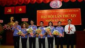 Đồng chí Mai Trung Thành (trái) và đồng chí Vũ Ngọc Tuất (phải) tặng hoa chúc mừng cấp ủy Chi bộ Viện Kiểm sát nhân dân quận nhiệm kỳ 2020 - 2025. Ảnh: VM
