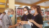 Các tình nguyện viên chọn hàng theo phiếu và trao tận tay cho người đi mua hàng