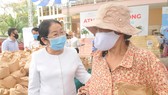 Phó Bí thư Thành ủy TPHCM Võ Thị Dung thăm hỏi người dân đến nhận gạo tại máy ATM gạo miễn phí ở Thủ Đức. Ảnh: CAO THĂNG