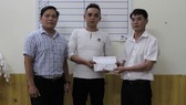 Đại diện Báo SGGP tại miền Trung và chính quyền địa phương trao tiền hỗ trợ cho gia đình cháu Huy