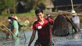 Sau tiếng kẻng báo hiệu, hàng trăm người nông dân cùng đổ xuống trằm để tham gia bắt cá