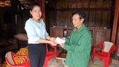 Bà Cao Thị Hoa, Phó Chủ tịch UBND xã Minh Hóa, thay mặt bạn đọc Báo SGGP trao số tiền 10 triệu đồng đến cựu binh Trương Văn Thanh