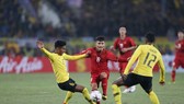 Quang Hải giữa vòng vây của hậu vệ Malaysia. Ảnh: DŨNG PHƯƠNG
