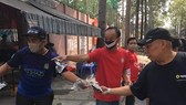 Hội CĐV CLB TPHCM phát khẩu trang cho người đi đường trên đường Đào Duy Từ. Ảnh: Anh Trần