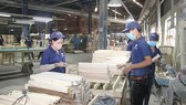 Workers process wood products for export at Tuong Van Company in Bac Tan Uyen District in Binh Duong Province. (Photo: SGGP)