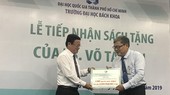 Deputy chairman of Committee for Overseas Vietnamese Vo Thanh Chat (L) gives the books to HCMCUT representative (Photo: SGGP)