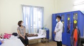 Nhân viên y tế thăm hỏi bệnh nhân đang điều trị tại bệnh viện. Ảnh: HOÀNG HÙNG