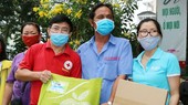 第五郡紅十字會主席黎勛峰(左)與「Habitat」項目管理人胡氏梅英(右)向貧困戶贈送禮物。