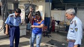 QLTT cùng nhân viên cây xăng đo lượng xăng trong bồn chứa
