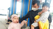 Anh Nguyễn Sửu cùng con đứng chờ xe khách vào Đồng Nai ngày 27-1 tại thị trấn Nghèn, huyện Can Lộc, Hà Tĩnh