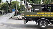 Phun thuốc khử trùng trên đường phố ở Hà Nội - Ảnh: Reuters