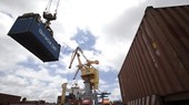 Các container được bốc xếp từ xe chở chuyên dụng lên tàu chở hàng. (Ảnh: Tuấn Anh/TTXVN)
