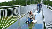 Một khách du lịch tạo dáng chụp hình sống ảo trên cầu kính duy nhất ở Tây Nguyên. (Ảnh: Nguyễn Dũng/TTXVN)