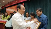 Secretary of HCMC Party Committee Nguyen Van Nen is giving merit certificates to collectives with excellent achievements in internal affairs tasks in 2022. (Photo: SGGP)