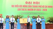 Secretary Nguyen Van Nen of the HCMC Party’s Committee is delivering the board with the line ‘HCMC Farmers for Solidarity – Innovation – Civilization – Development’ from the city Party’s Committee, People’s Committee, People’s Council, HCMC Vietnam Fatherland Front (Photo: SGGP)