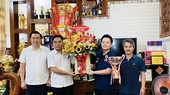 Ông Nguyễn Lộc Hà - Phó chủ tịch UBND tỉnh Bình Dương thay mặt lãnh đạo tỉnh Bình Dương tặng hoa và quà chúc mừng nhà vô địch thế giới Bao Phương Vinh tại nhà riêng. Ảnh: THÁI HẢI