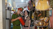 Công an hướng dẫn, kiểm tra cách sử dụng bình chữa cháy của tiểu thương các chợ. Ảnh: XUÂN QUỲNH