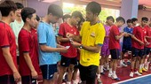 HLV Phạm Minh Giang lì xì đầu năm đến các học trò mới ở Cao Bằng. ẢNH: CLB