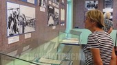 A foreign visitor contemplates pictures at the exhibition. (Photo: hcmcpv.org.vn)